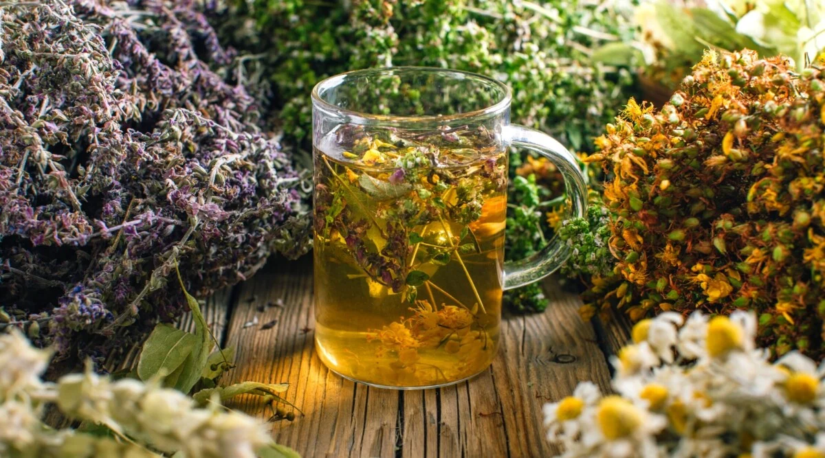 Steaming cup of herbal tea beside a timer